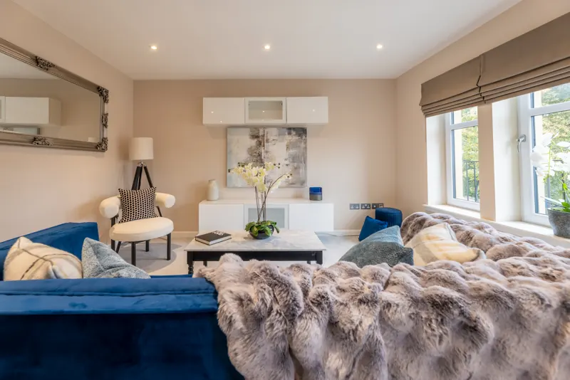 Staged living room with blue velvet sofa and boucle chair